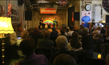 Billede af forfatterne Morten Ramsland og Iben Mondrup i samtale på Generatorscenen til Ordkraft 2019. I rummet sidder en gruppe publikummer tæt på stole og følger med i samtalen.